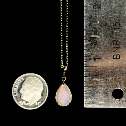 Size reference image of the opal necklace next to a dime and ruler, showing the pendant measuring approximately 0.5 inches.