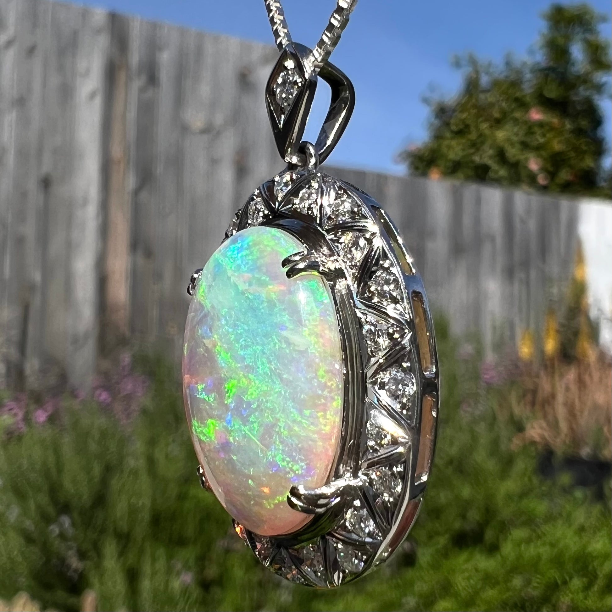 Angled photo of pendant in sunlight showing blue flashes on opposite side.