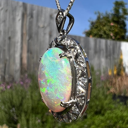 Angled photo of pendant in sunlight showing blue flashes on opposite side.