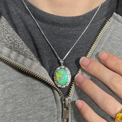 Crystal opal necklace worn over a black t-shirt with zip-up sweatshirt, showing green and red flashes.