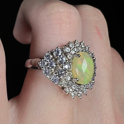 Ethiopian opal ring with tanzanite accents, worn on finger