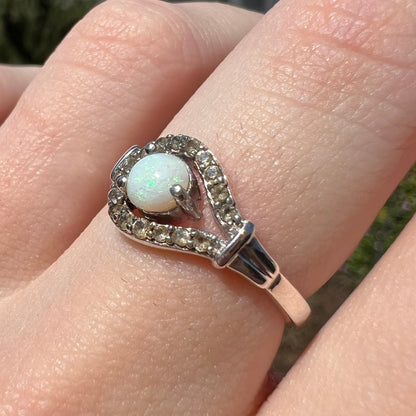 Smoky quartz accents of silver opal ring in focus, worn on finger and shown from angle in natural light