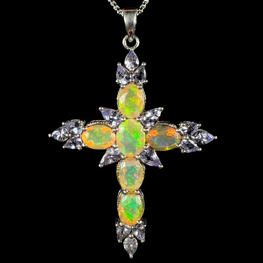 An Ethiopian opal and tanzanite cross necklace made from sterling silver, shown from the front.
