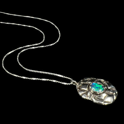 A unisex sterling silver pinecone-inspired opal triplet necklace with green color play.