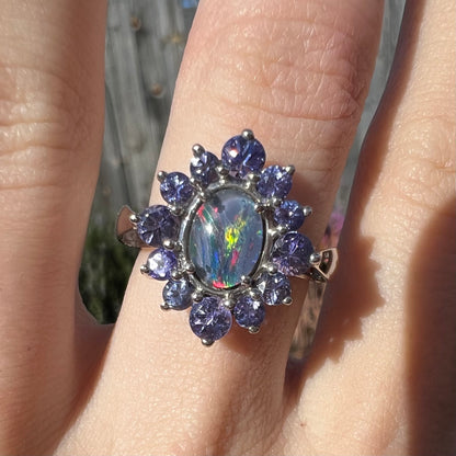 A sterling silver floating-style ring mounted with a black opal triplet in a halo of tanzanite stones.