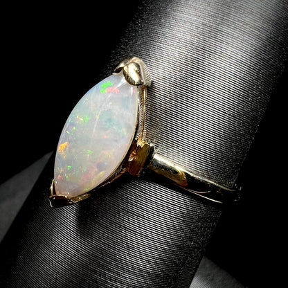 A marquise cut natural opal solitaire ring in yellow gold.