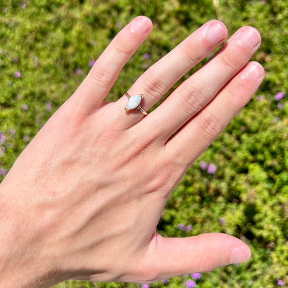 A marquise cut natural opal solitaire ring in yellow gold.