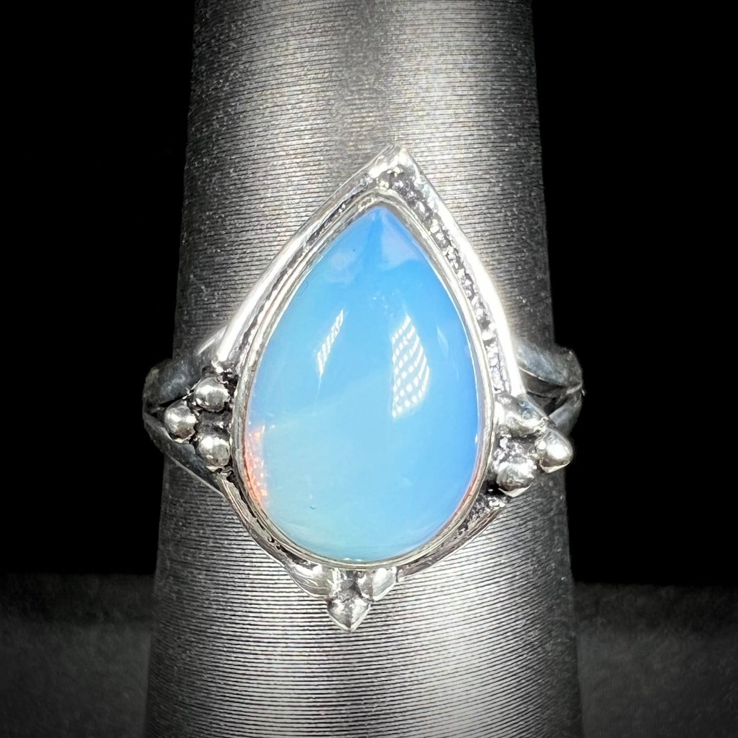 A handmade white metal ring set with a pear shaped opalite cabochon.