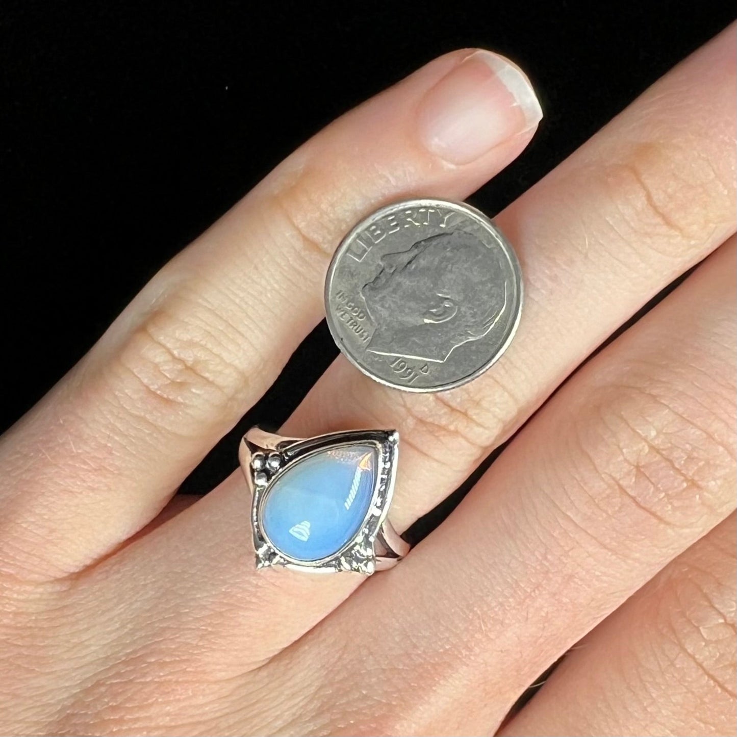 A handmade white metal ring set with a pear shaped opalite cabochon.