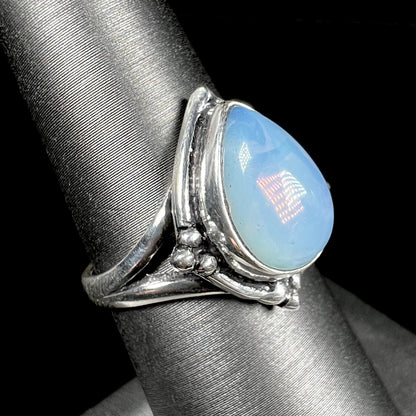 A handmade white metal ring set with a pear shaped opalite cabochon.