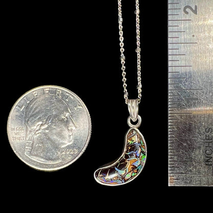 A sterling silver necklace bezel set with a natural Koroit boulder opal stone.  The stone is shaped like a crescent moon.