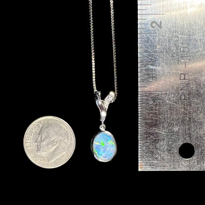 A sterling silver necklace set with a natural black opal doublet and white zircon accent stones.