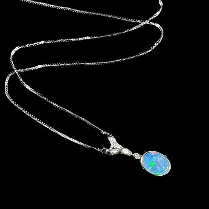 A sterling silver necklace set with a natural black opal doublet and white zircon accent stones.