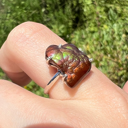 Opposite angled outdoor view of fire agate ring showing green and purple banding.
