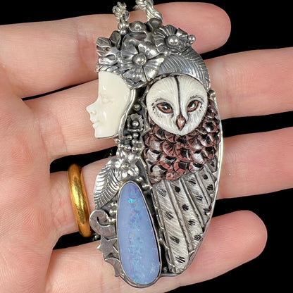 A woman and owl necklace with a nature-inspired motif, made from sterling silver, bone, and an opal doublet.