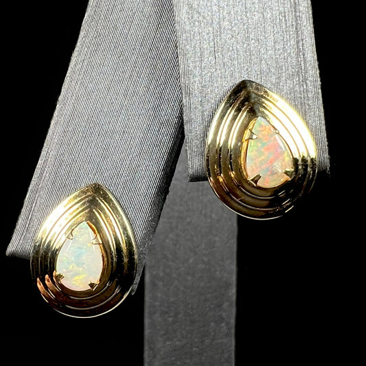 A pair of pear shaped natural opals mounted in yellow gold pushback stud earrings.