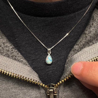 A dainty, sterling silver necklace bezel set with a natural, pear shaped opal stone.
