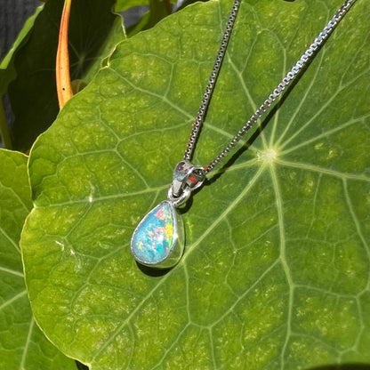 A dainty, sterling silver necklace bezel set with a natural, pear shaped opal stone.