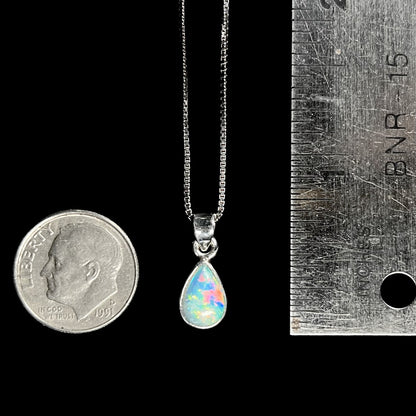 A dainty, sterling silver necklace bezel set with a natural, pear shaped opal stone.