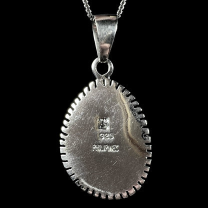 The back side of a Southwest-style sterling silver pendant signed with an artist's initials, "925", and "PHILIPINES".