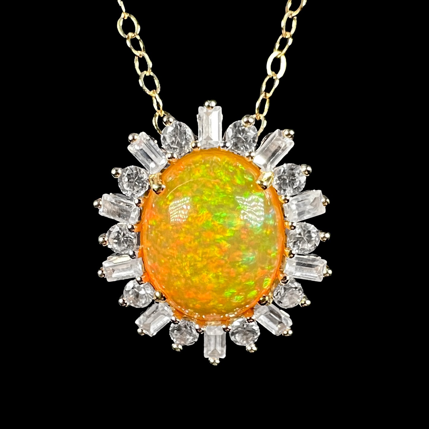 Front close-up of Ethiopian fire opal and white zircon halo necklace in 14k yellow gold on gold chain. The opal has subtle green, orange, and red pinfire pattern.