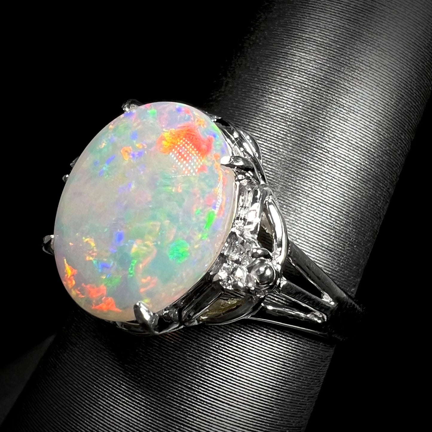 A platinum ring mounted with a 2.36ct Australian opal and diamond accents.  The opal has reddish orange colors.