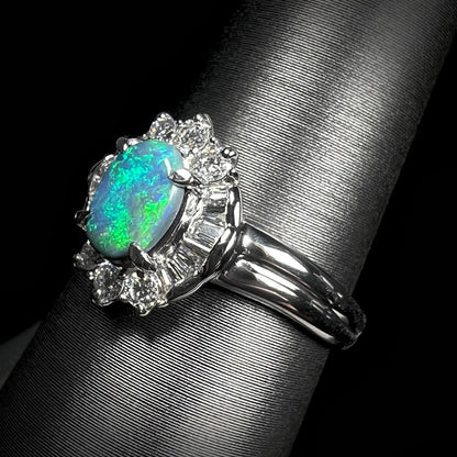 Macro angled view showing diamond halo and green fire in platinum black opal engagement ring.