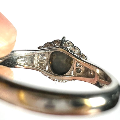 Underside view of a platinum ring set with natural Australian black opal showing its irregular natural gray potch and matrix backing.