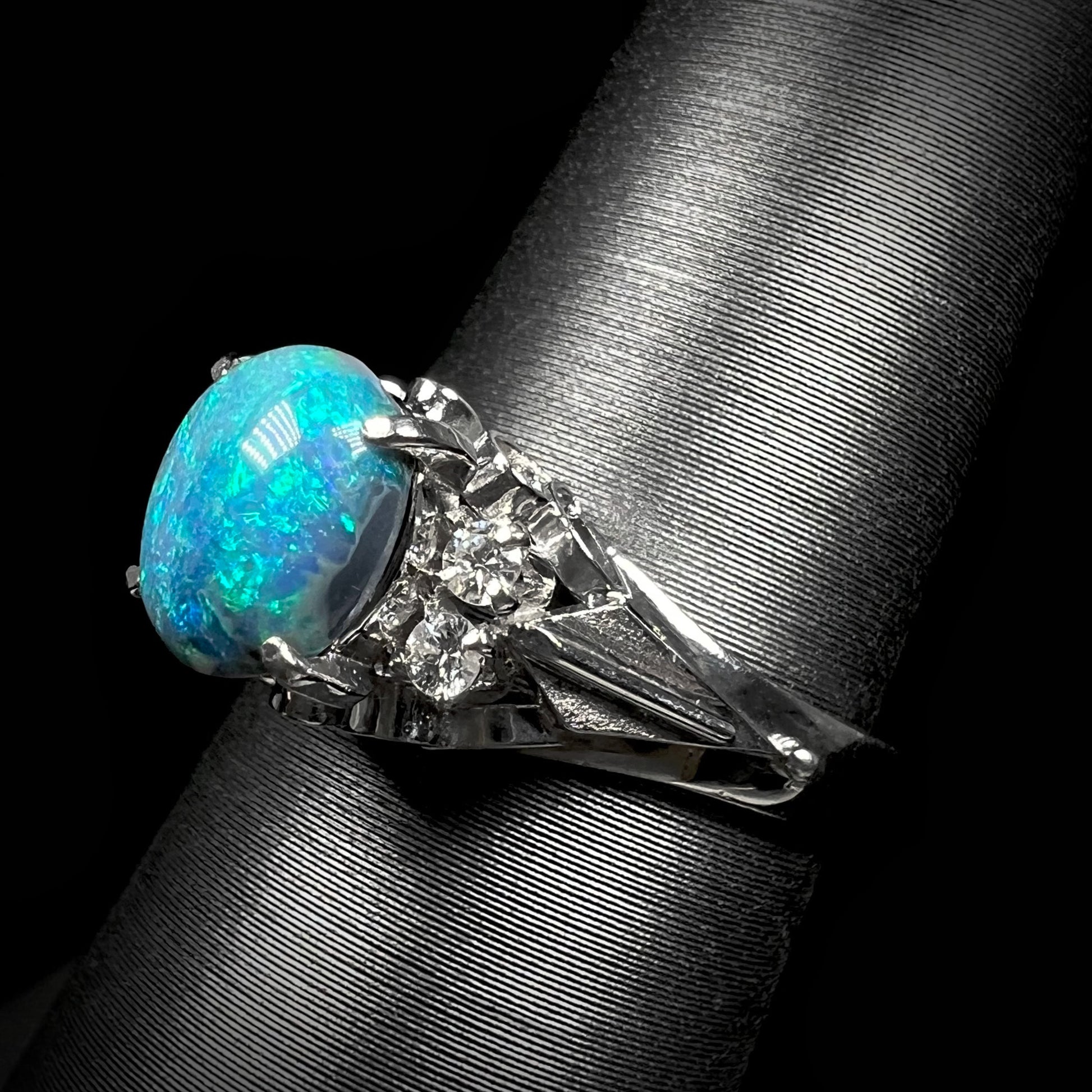 A platinum filigree ring mounted with a 0.89ct Lightning Ridge black opal and diamond accents.