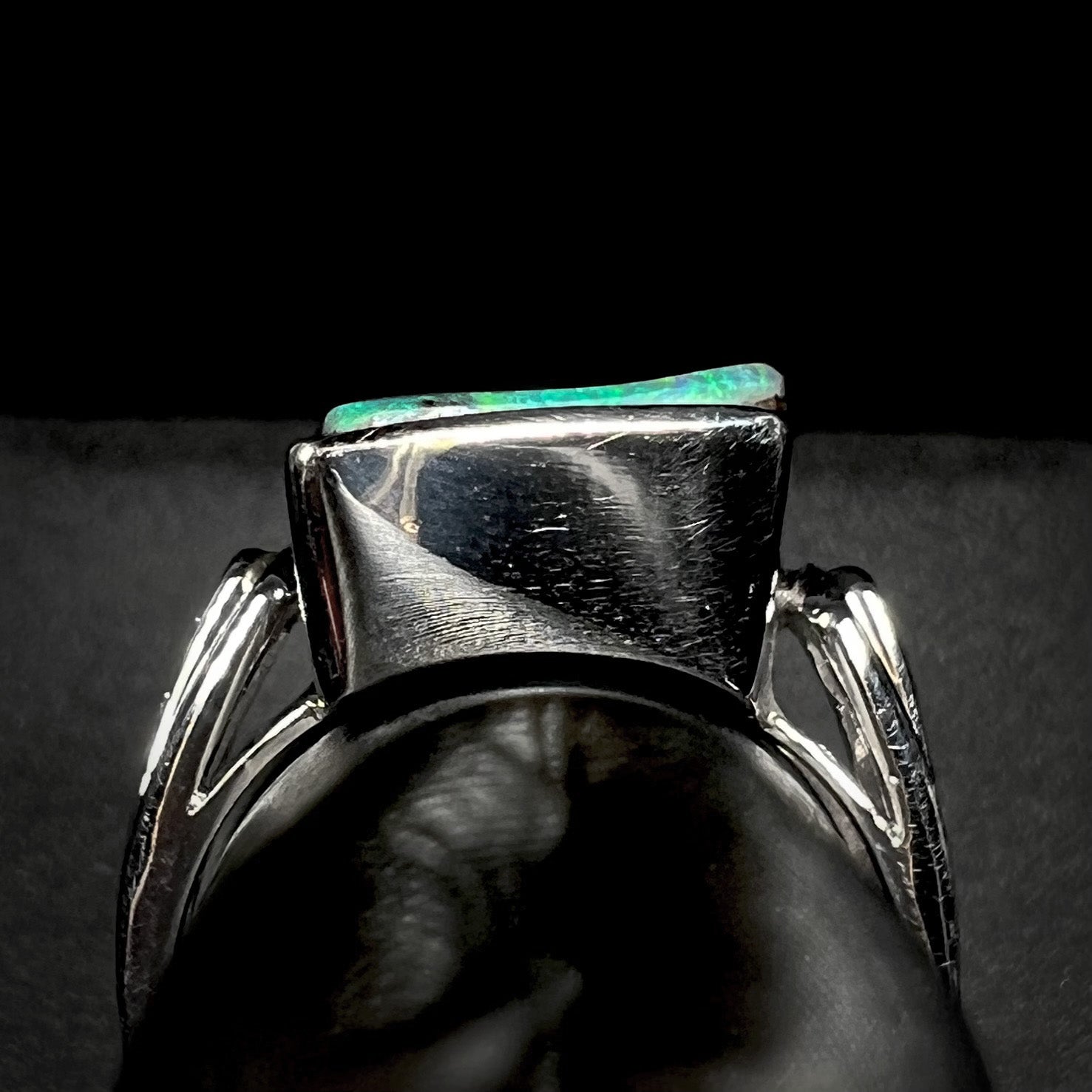 Gallery view of a platinum boulder opal ring on a ring display, shown against a black background.