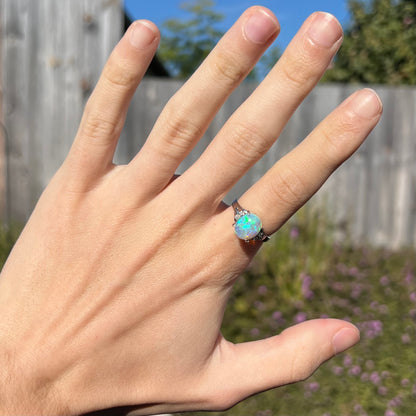 A platinum filigree ring set with a Lightning Ridge crystal opal and diamond accents.