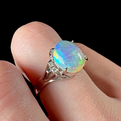 A platinum filigree ring set with a Lightning Ridge crystal opal and diamond accents.