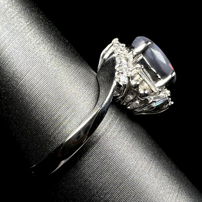 The side shank view of a platinum dark opal and diamond ring, shown on ring display.