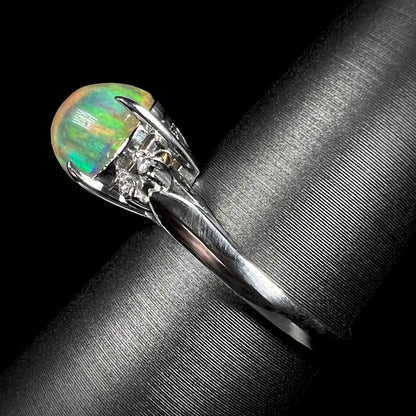 Side view of a platinum fire opal engagement ring, showcasing its elegant band, filigree details, and a 2.28ct Mexican fire opal center stone.