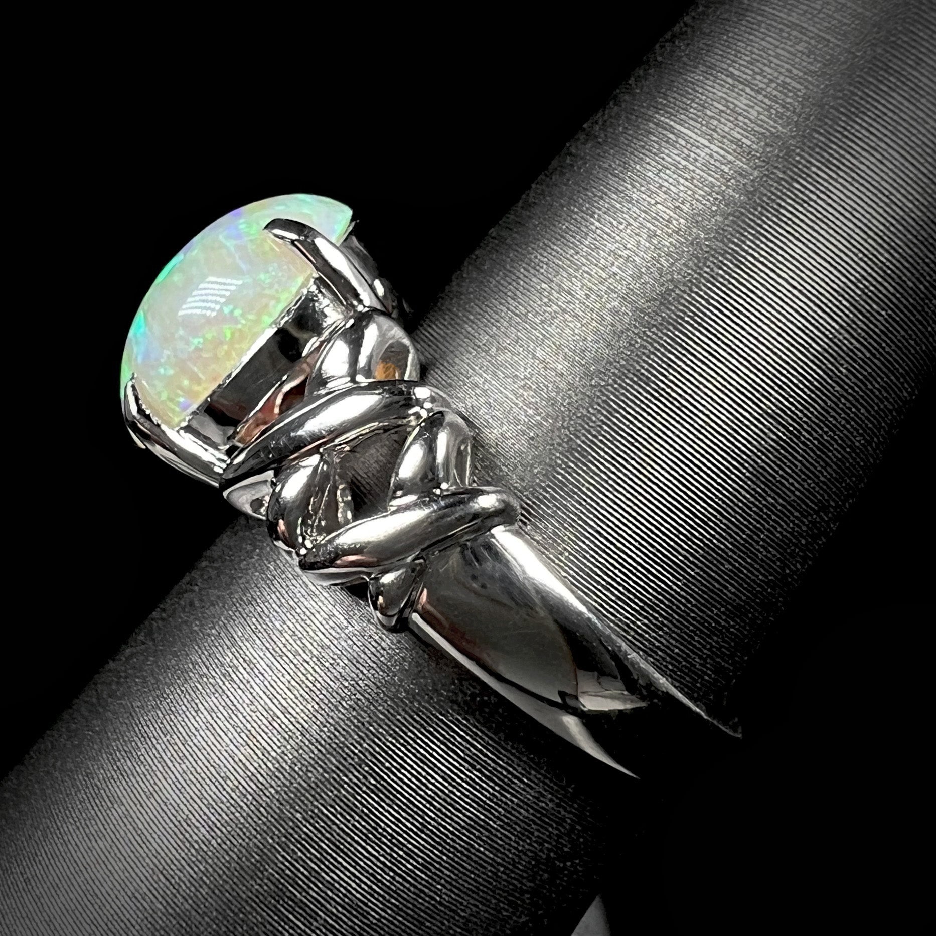 The side view of a platinum opal crisscross ring.  The band has a high polish.