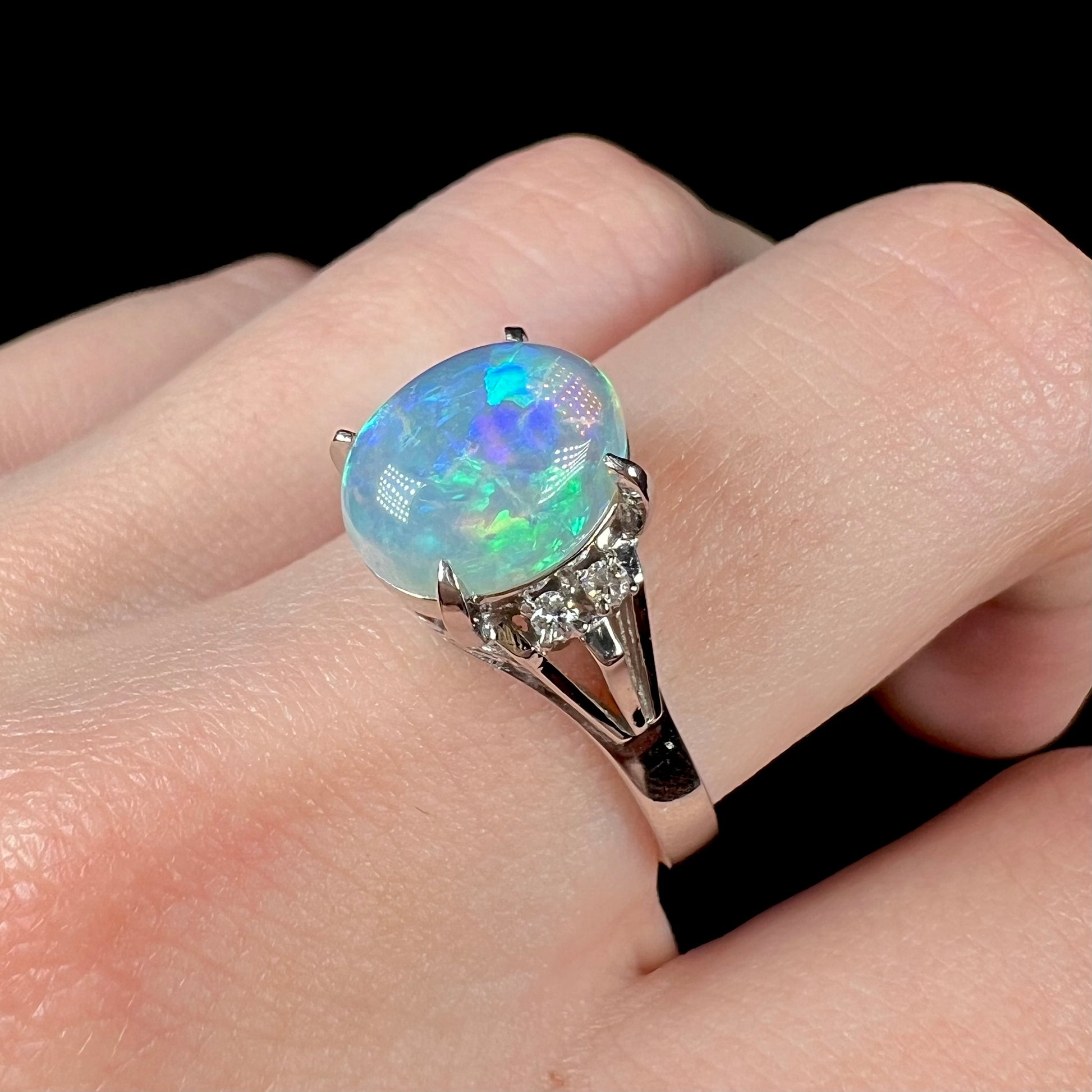 A platinum filigree ring set with a Lightning Ridge crystal opal and diamond accents.