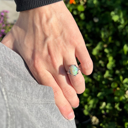 A Japanese-style platinum ring mounted with a Coober Pedy opal and diamond accents.