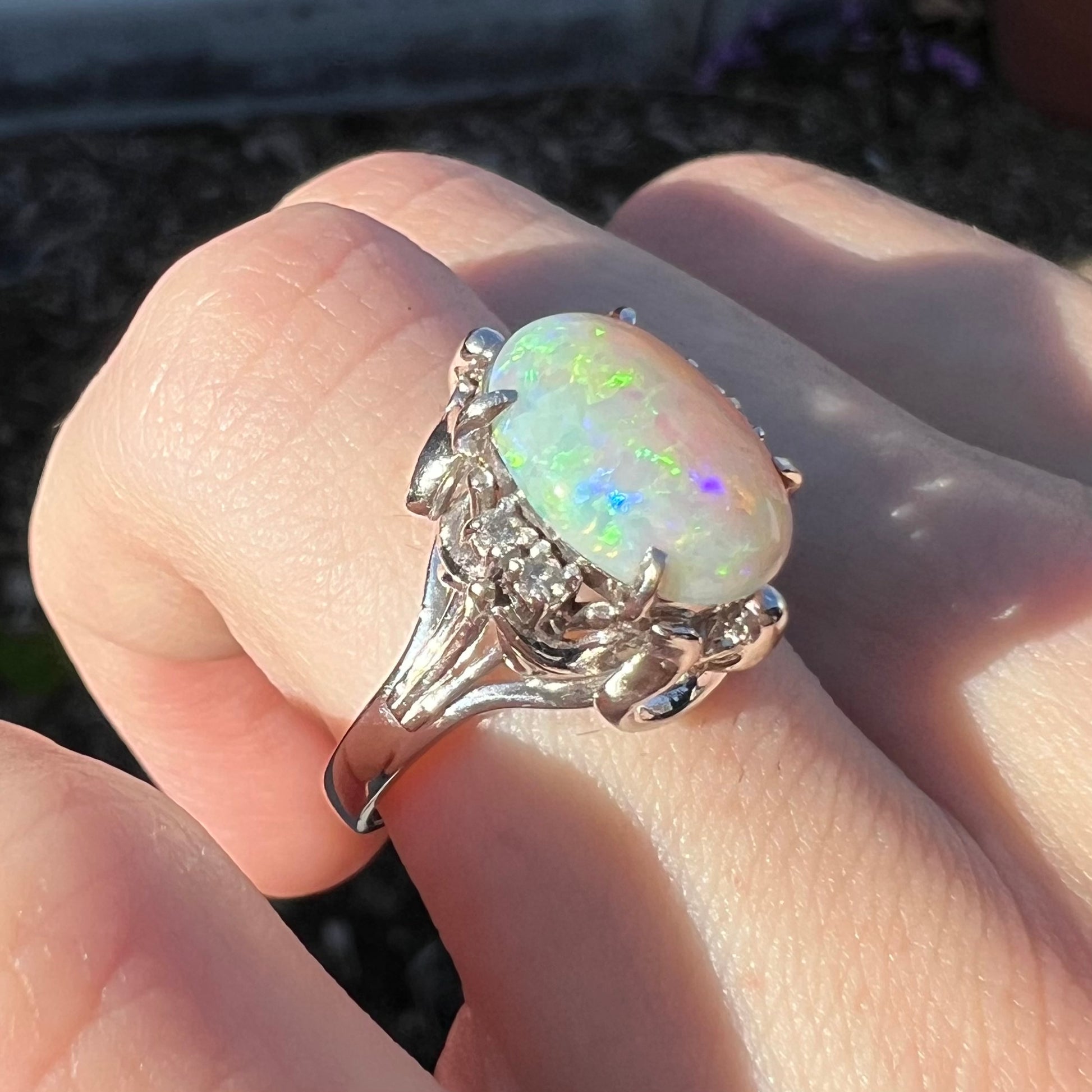 A Japanese-style platinum ring mounted with a Coober Pedy opal and diamond accents.