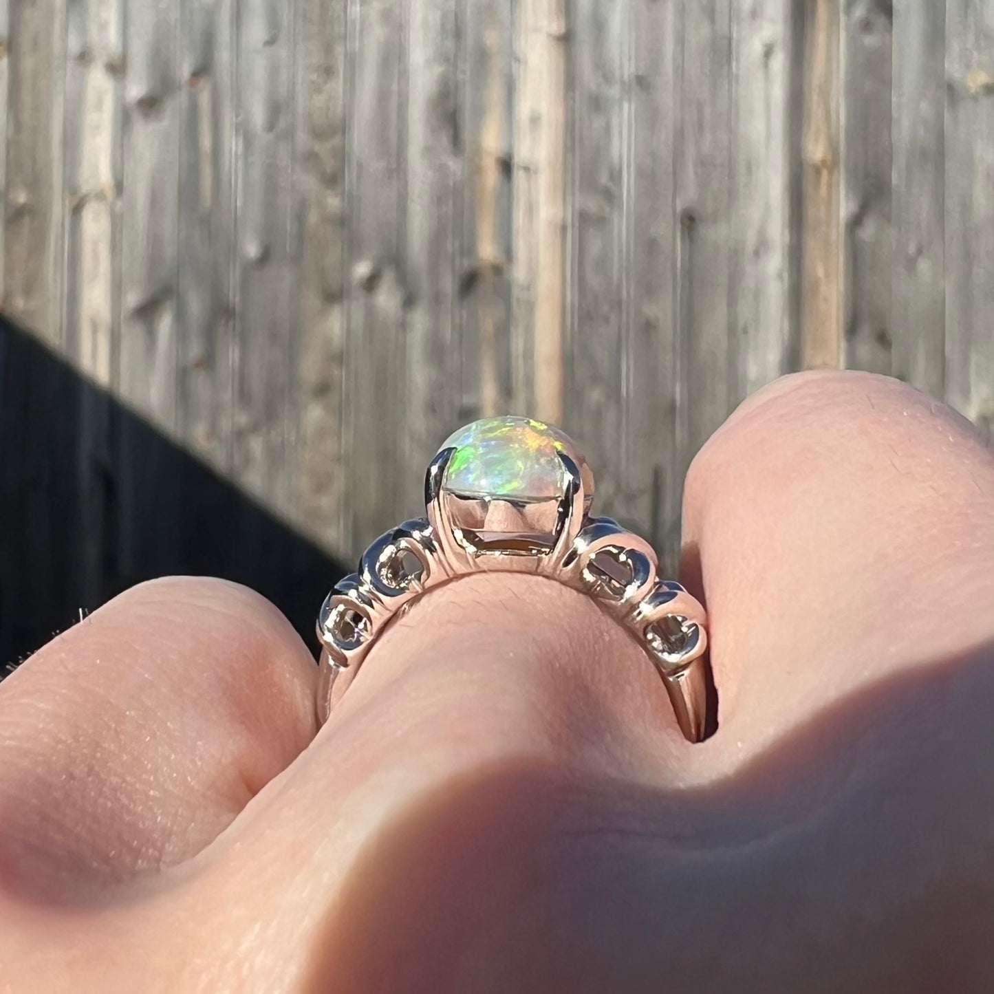 Gallery view of a platinum opal ring in the sunlight.