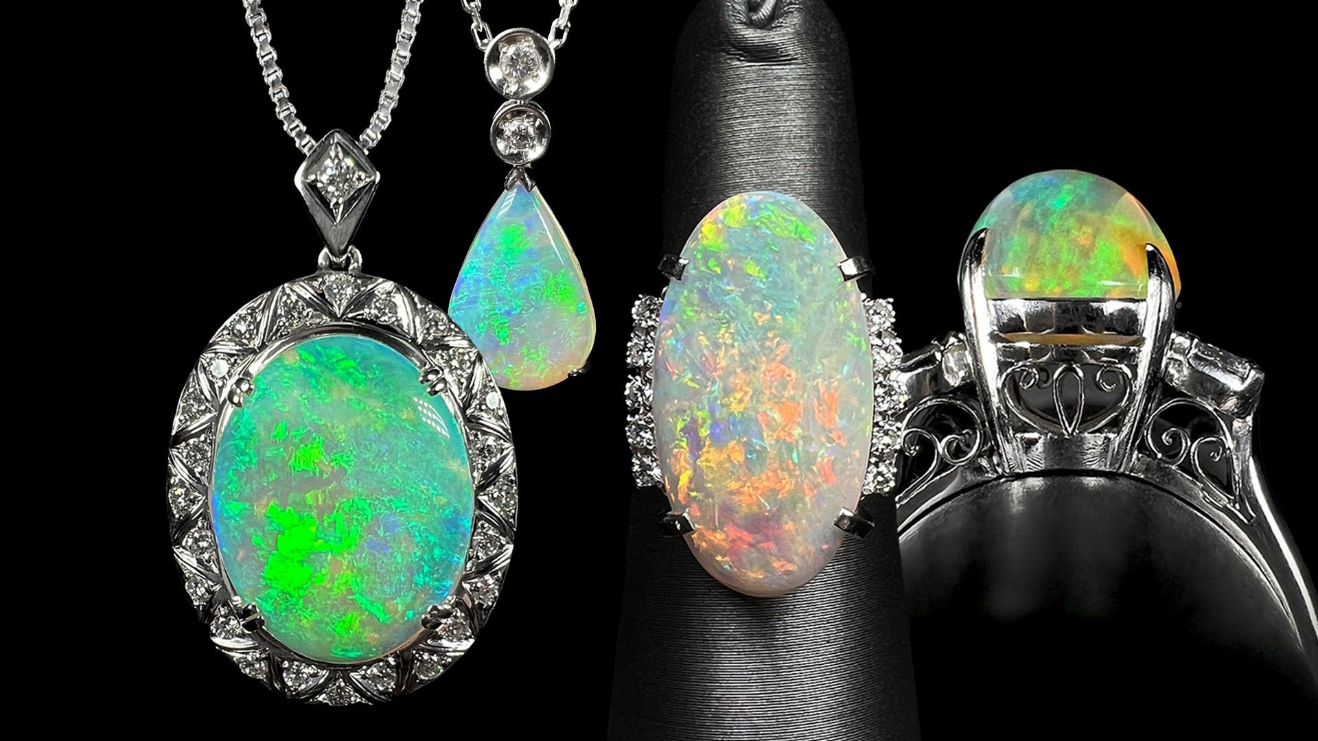 Two platinum Australian opal and diamond necklaces shown hanging next to two platinum opal rings displayed on ring displays.  One opal ring is shown from its gallery view, displaying fine filigree details.