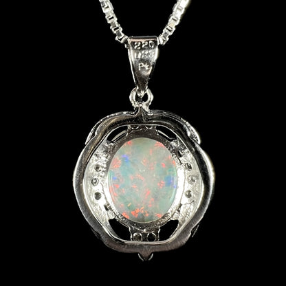 Back view of a platinum opal necklace against a black background.  The bail is stamped "220", "023", and "Pt".