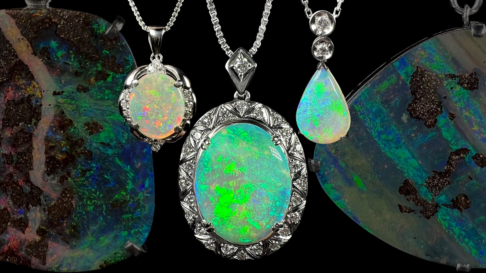 Three platinum opal and diamond necklaces hanging against a black background.  Two large boulder opal pendants are seen, faded, in the background.