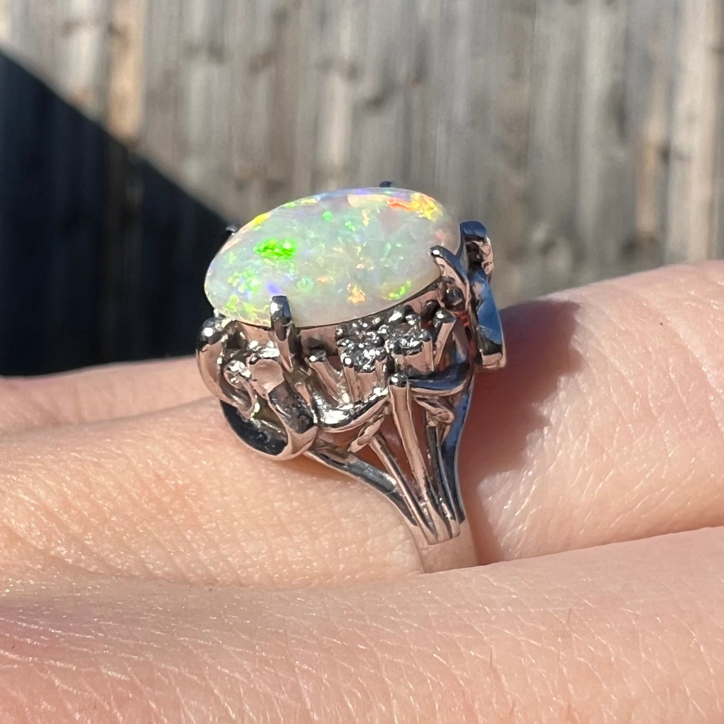 A Japanese-style platinum ring mounted with a Coober Pedy opal and diamond accents.