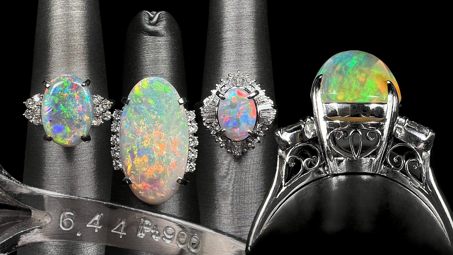 Three platinum Australian opal and diamond rings lined up on ring displays next to a larger platinum filigree Mexican fire opal ring, shown from its gallery view.  Below, the inside of a ring's shank hallmarked "6.44" and "Pt900" is shown.