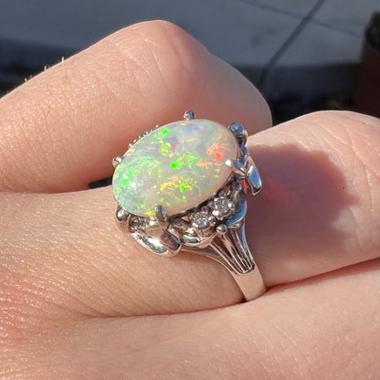 A Japanese-style platinum ring mounted with a Coober Pedy opal and diamond accents.