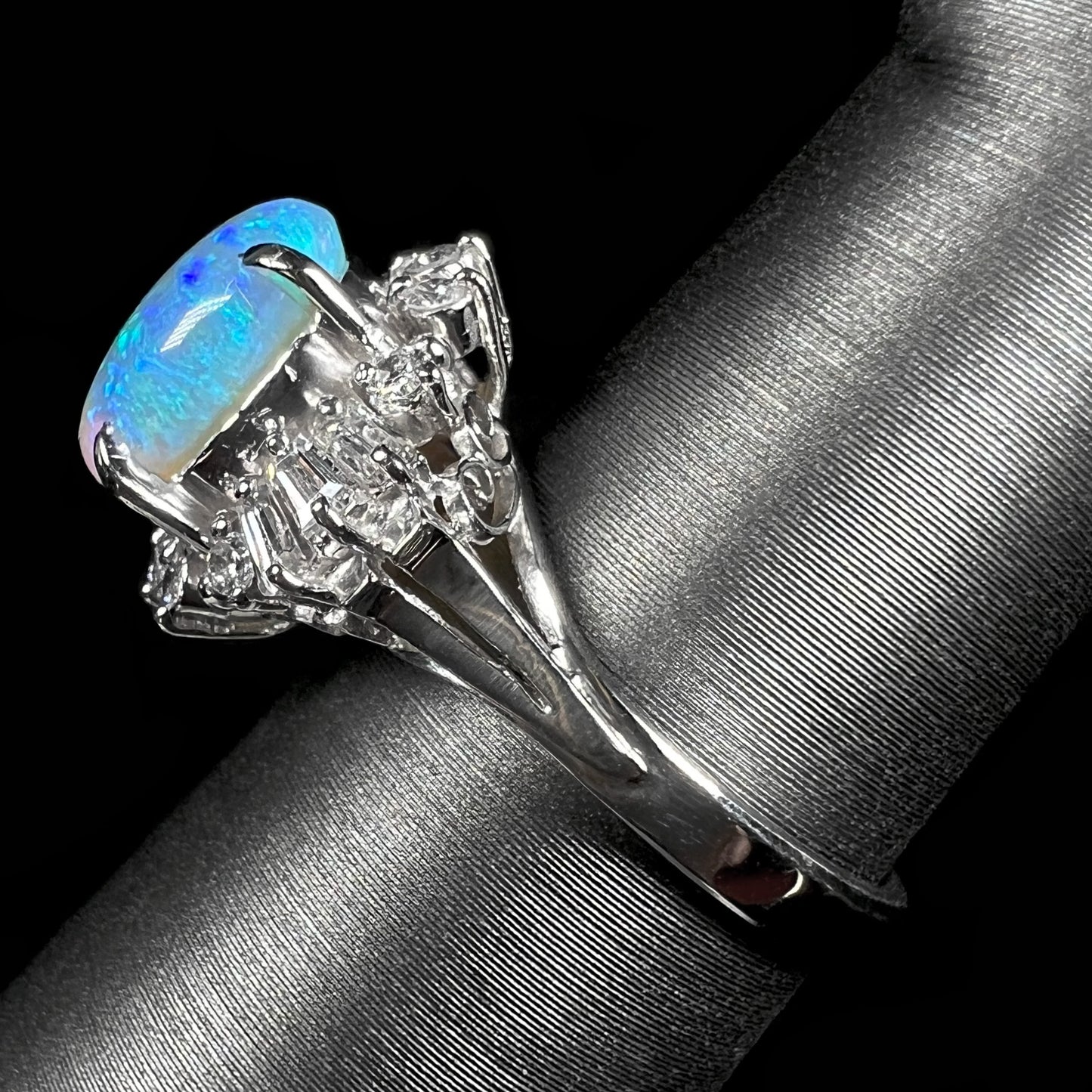 Side view of platinum semi-crystal opal engagement ring from the opposite side, showing the vintage platinum shank.