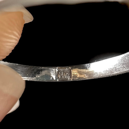 The inside of a platinum ring's shank stamped, "PM".