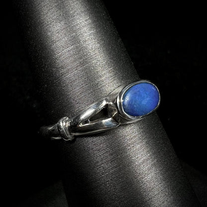 Preowned silver solitaire ring set with horizontal blue Australian opal doublet, shown close-up on ring display 