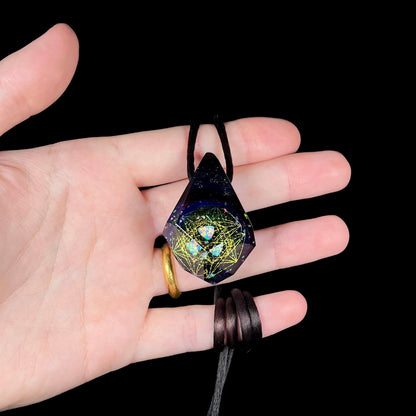 Hand holding an opal in faceted purple glass pendant with a galactic multiverse motif, shown against a black background.