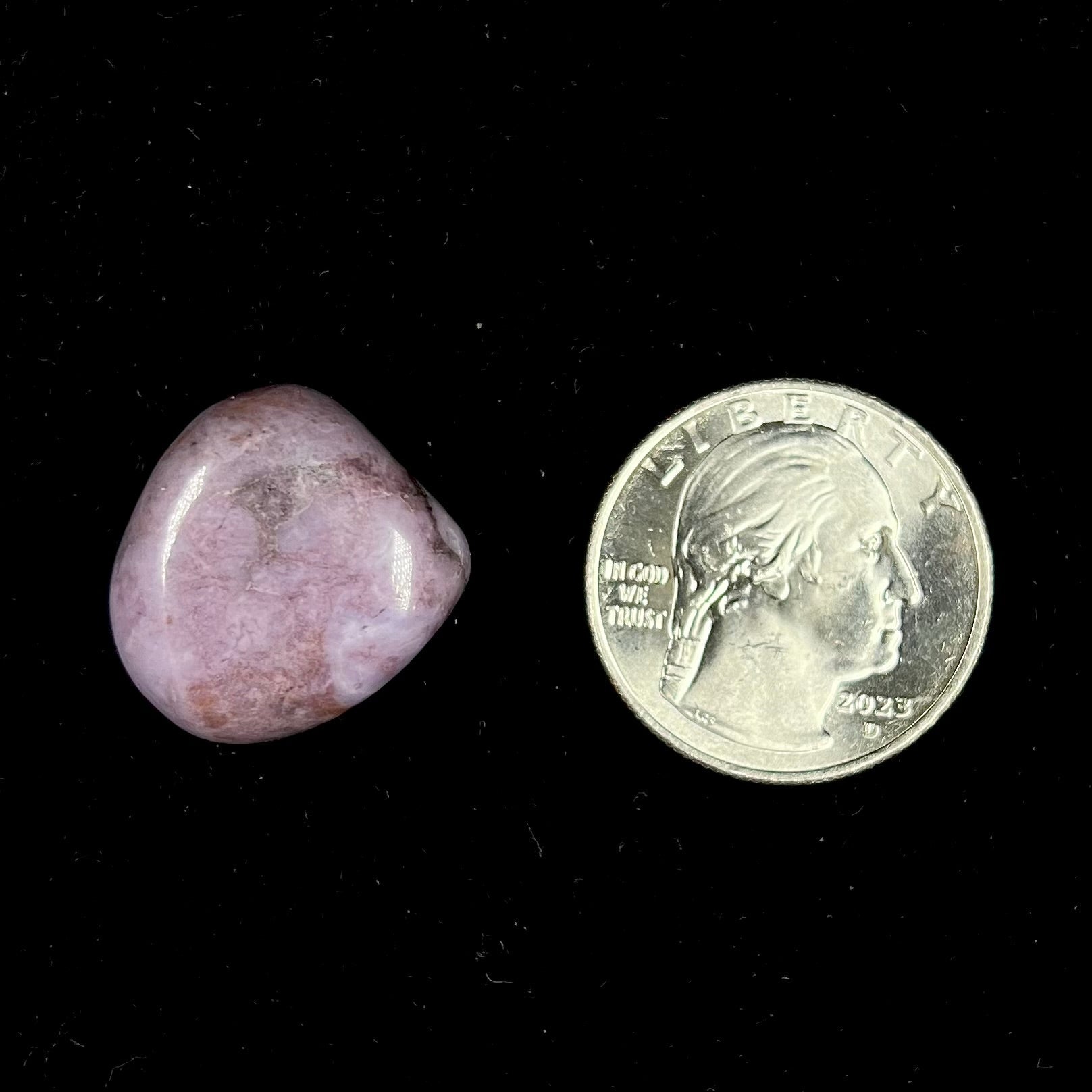 A tumble polished turkiyenite purple jade stone from Bursa, Turkey.  Material has reddish marbling.